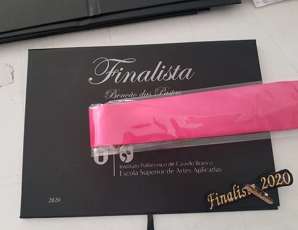 Pastas com personalização e fitas para assinalar a conclusão do percurso académico.