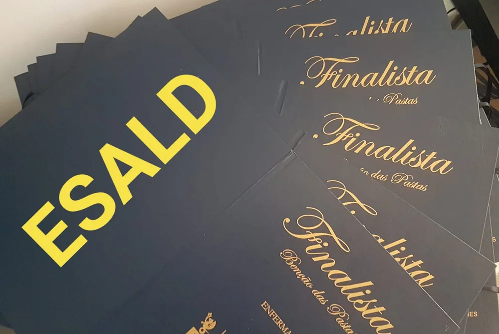 Pastas com personalização e fitas para assinalar a conclusão do percurso académico.