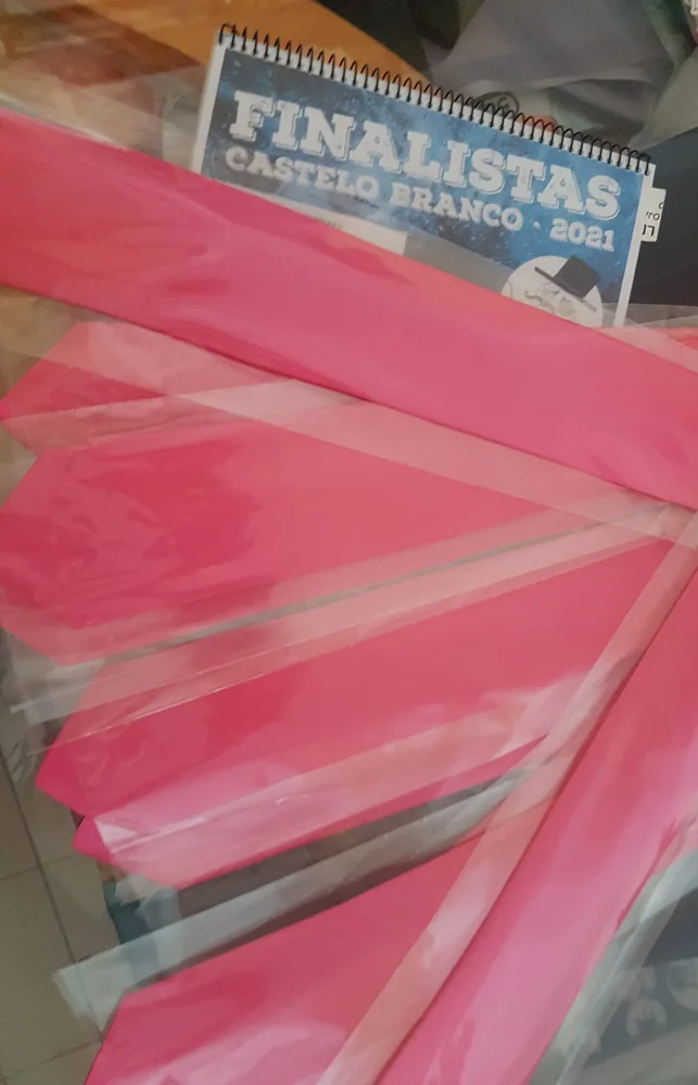 Pastas com personalização e fitas para assinalar a conclusão do percurso académico.