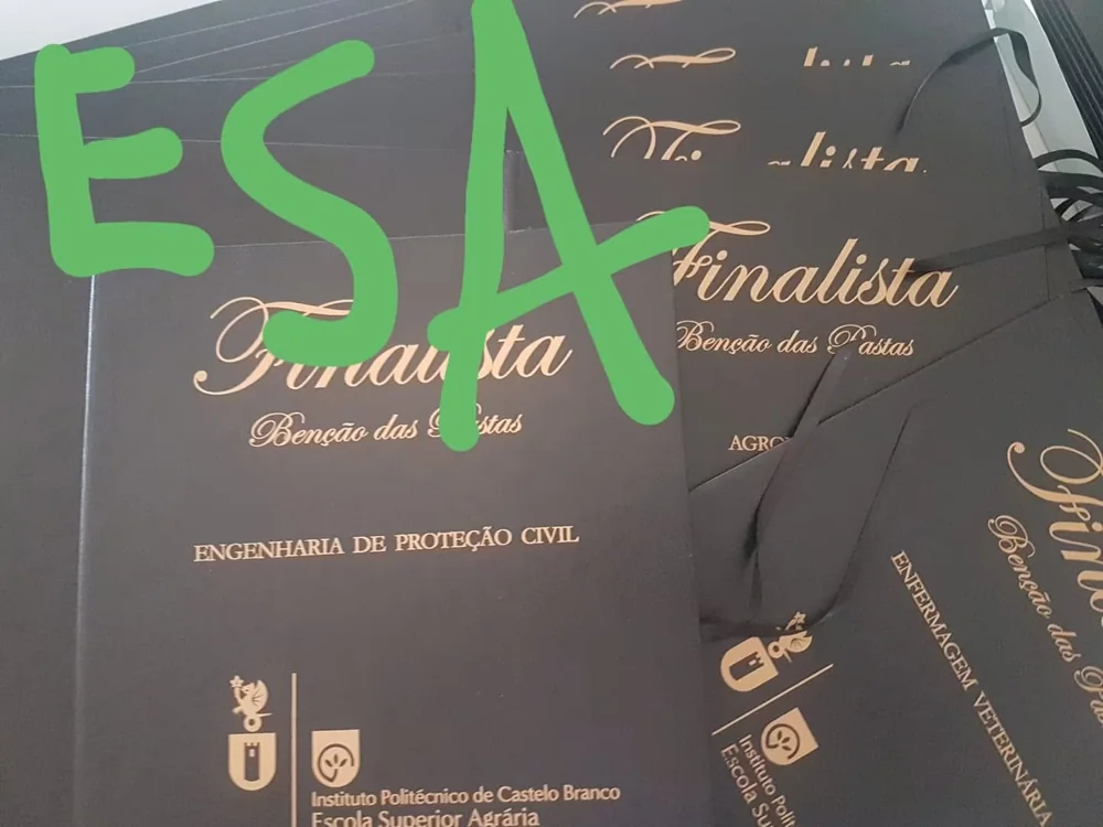 Pastas com personalização e fitas para assinalar a conclusão do percurso académico.