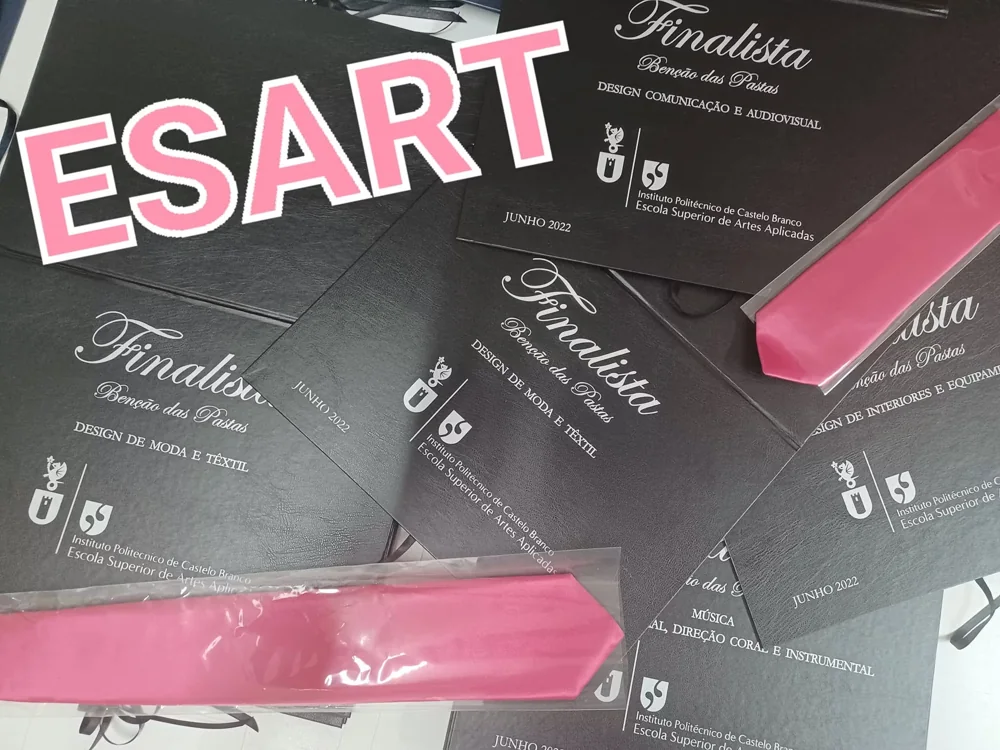 Pastas com personalização e fitas para assinalar a conclusão do percurso académico.