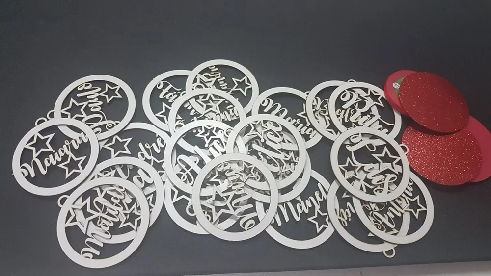 Peças recortadas com nomes e motivos decorativos para pendurar.