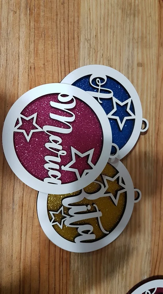 Peças recortadas com nomes e motivos decorativos para pendurar.