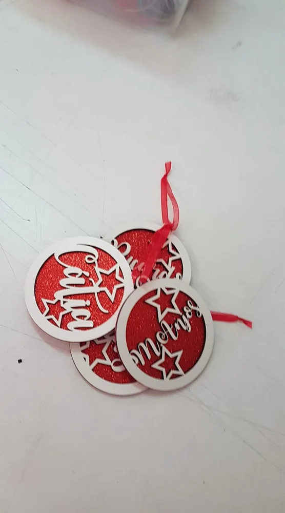 Peças recortadas com nomes e motivos decorativos para pendurar.