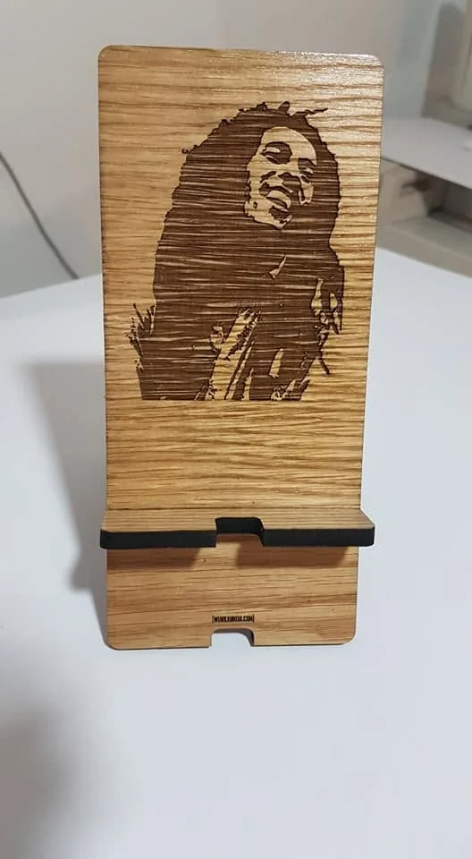 Suporte para pousar o telemóvel, com elementos decorativos ou imagem personalizada.