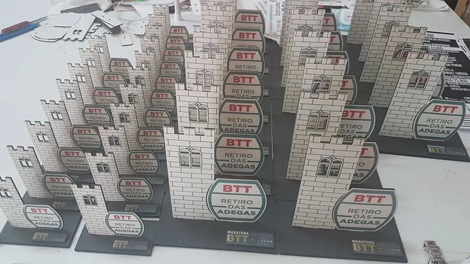 Conjunto de troféus com formas e elementos personalizados para evento.