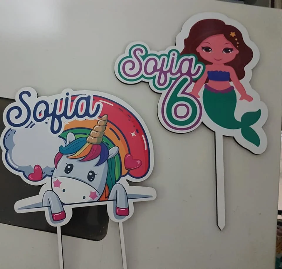 Peça de decoração para bolo com nome, número ou motivo festivo.