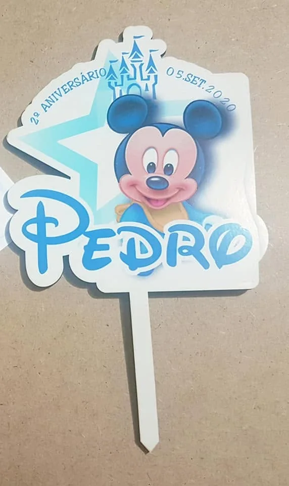 Peça de decoração para bolo com nome, número ou motivo festivo.
