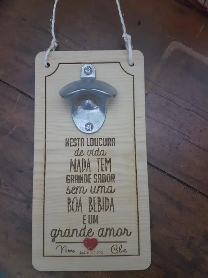 Abre-garrafas montado numa placa com mensagens e elementos personalizados.