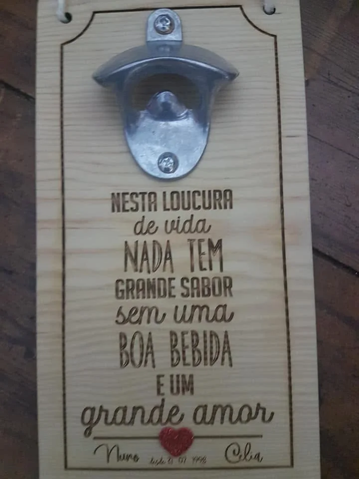 Abre-garrafas montado numa placa com mensagens e elementos personalizados.