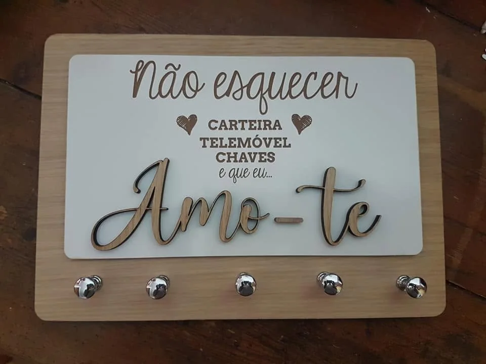Suporte de parede com ganchos e elementos personalizados para organizar chaves.