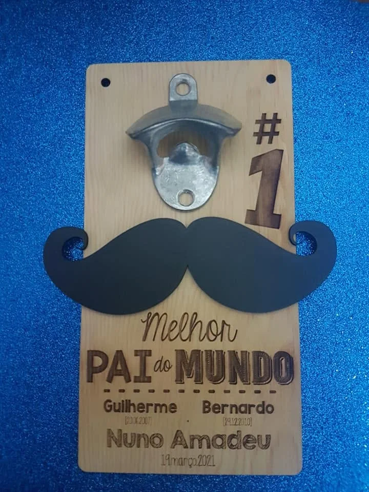 Abre-garrafas montado numa placa com mensagens e elementos personalizados.