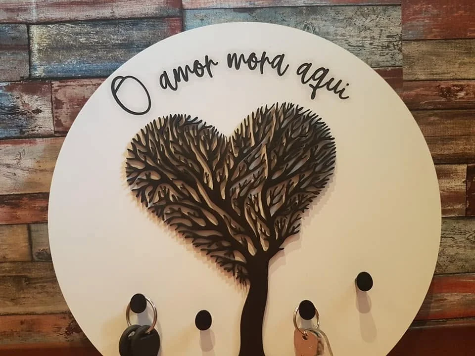 Suporte de parede com ganchos e elementos personalizados para organizar chaves.