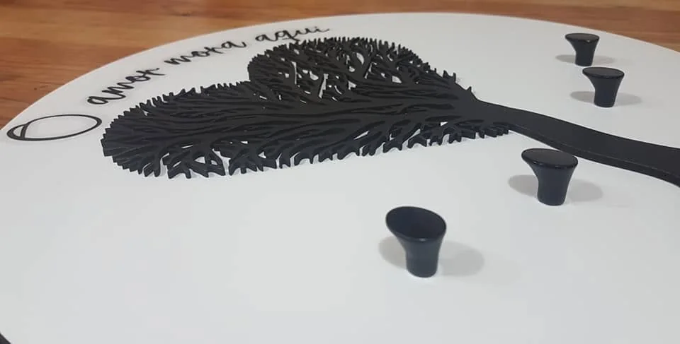 Suporte de parede com ganchos e elementos personalizados para organizar chaves.