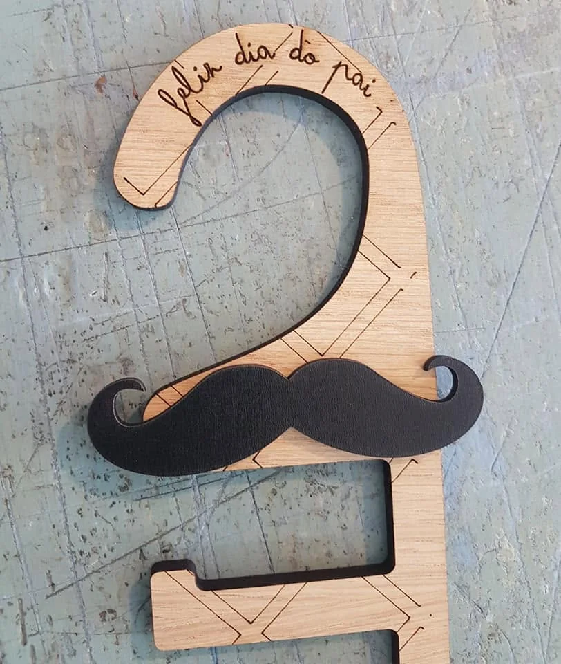 Suporte com recortes e motivo decorativo de bigode.