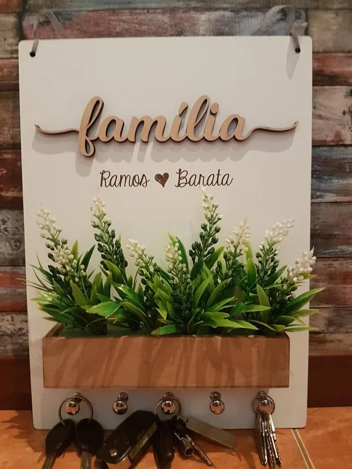 Suporte de parede com ganchos e elementos personalizados para organizar chaves.