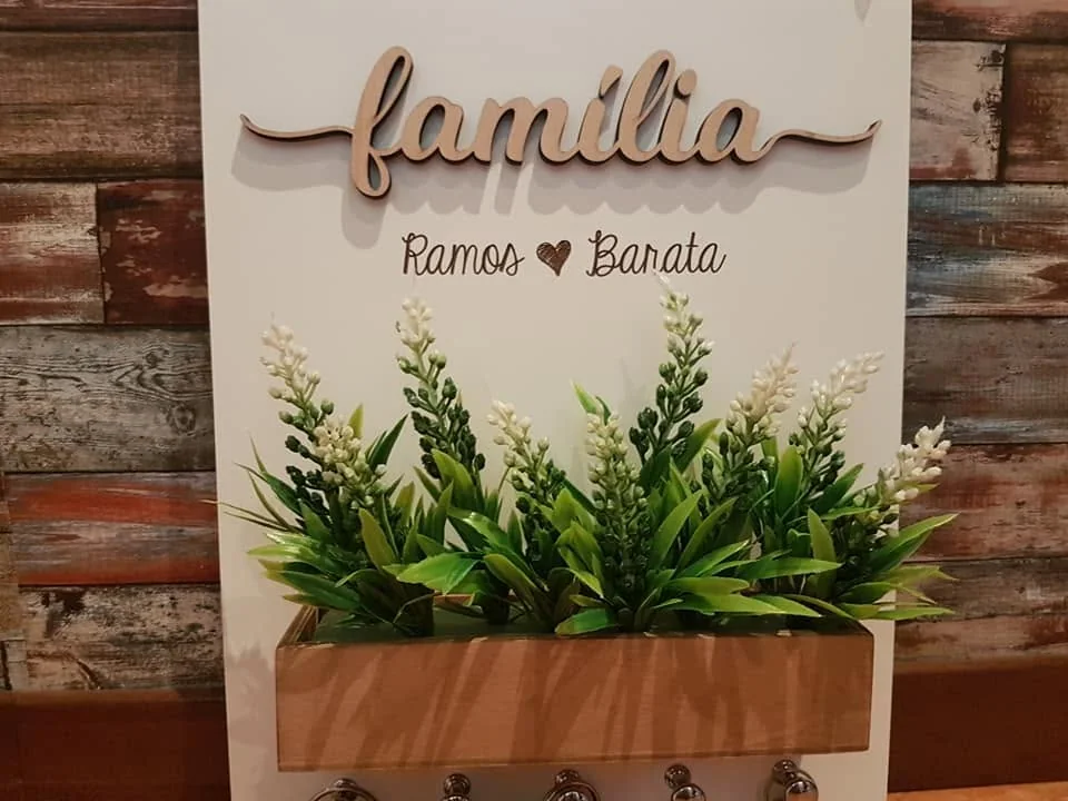 Suporte de parede com ganchos e elementos personalizados para organizar chaves.