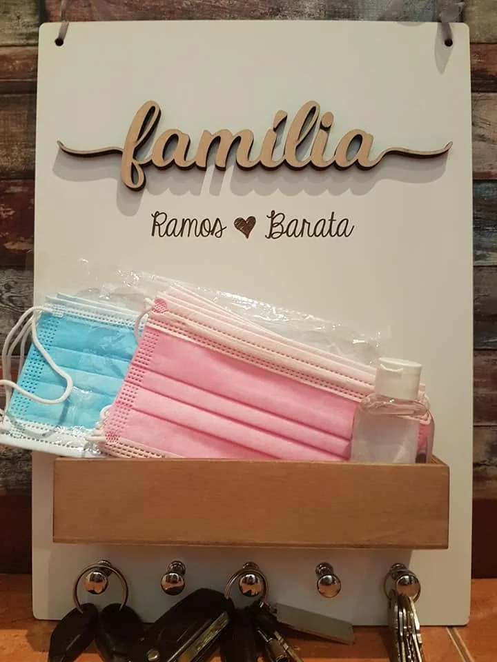 Suporte de parede com ganchos e elementos personalizados para organizar chaves.