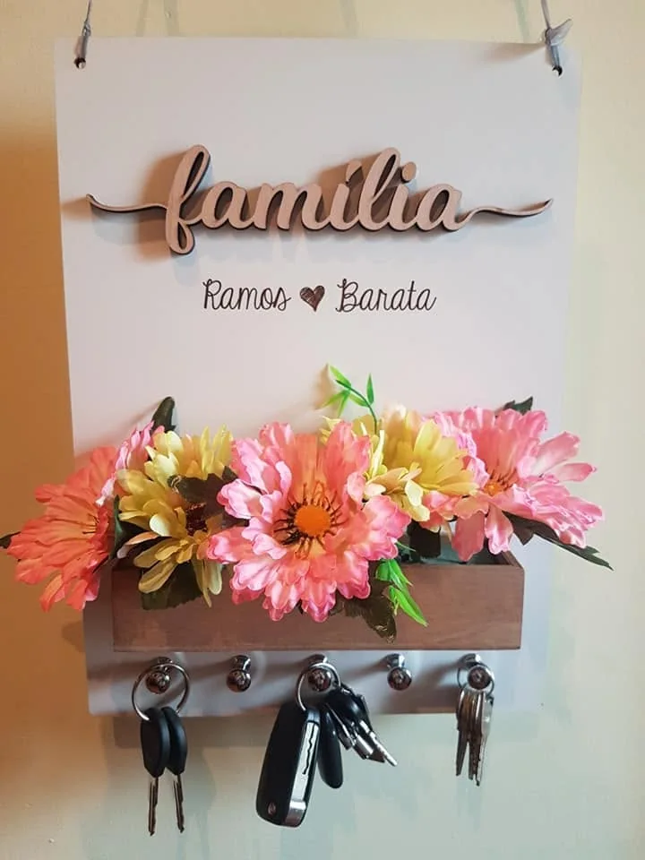Suporte de parede com ganchos e elementos personalizados para organizar chaves.