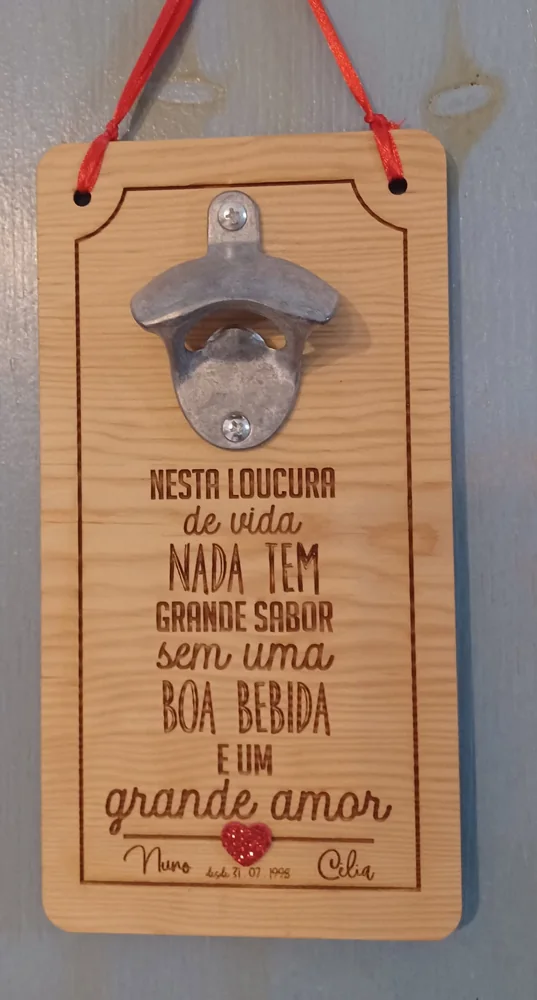 Abre-garrafas montado numa placa com mensagens e elementos personalizados.