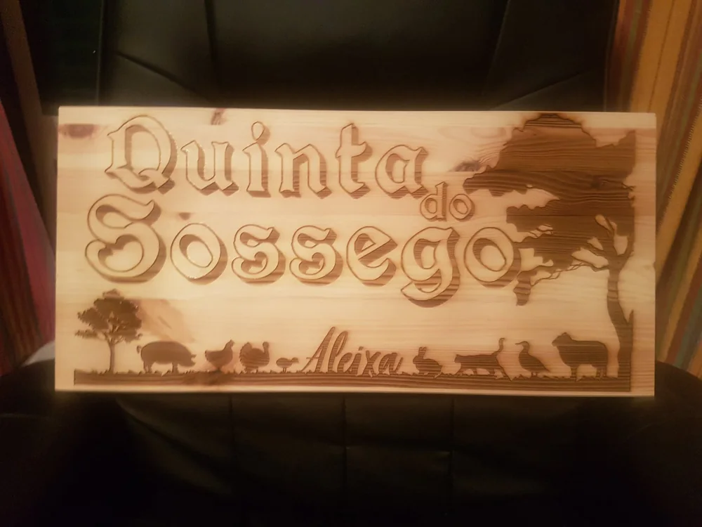 Placa retangular em madeira com nome do espaço e silhuetas decorativas.