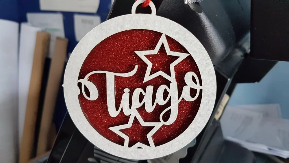 Peças recortadas com nomes e motivos decorativos para pendurar.