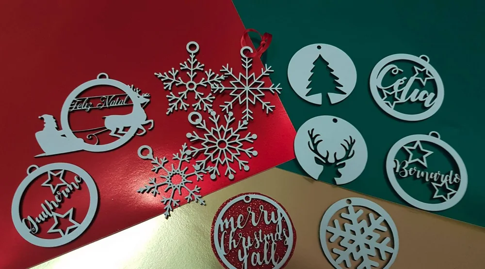 Peças recortadas com nomes e motivos decorativos para pendurar.
